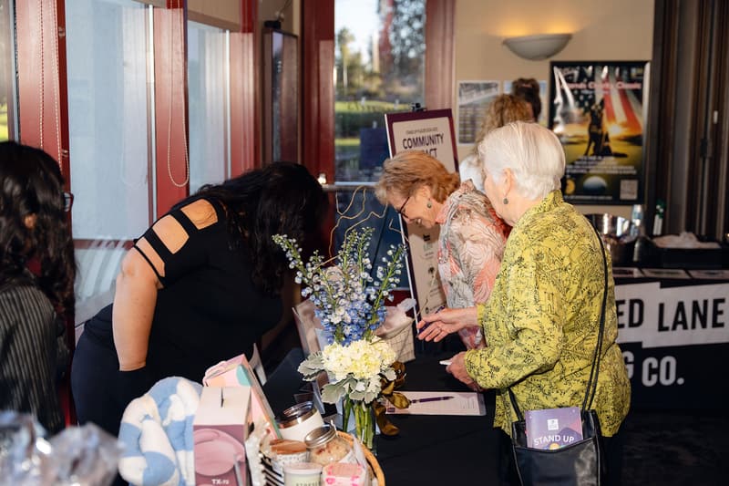 Guests browse items on display tables at the silent auction.