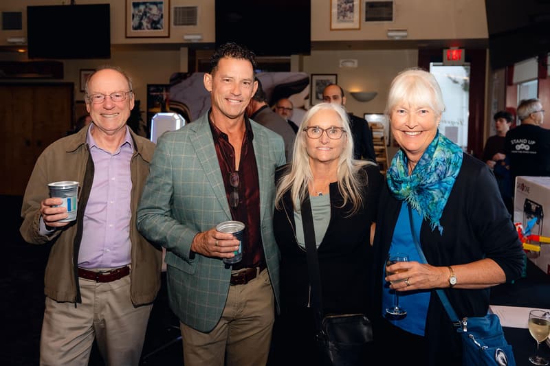 Four smiling guests pose together at the gala.