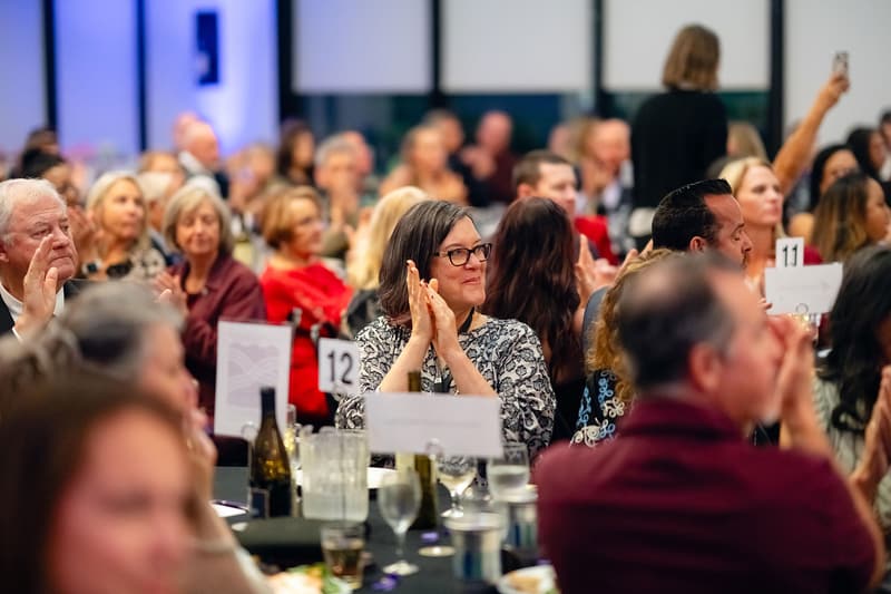 Guests seated at round tables in a full ballroom during the gala dinner.